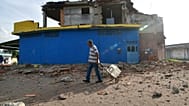 Un hombre pasa junto a una casa dañada en Morón, cerca del epicentro de los dos terremotos que azotaron Venezuela, el 25 de junio de 2026.