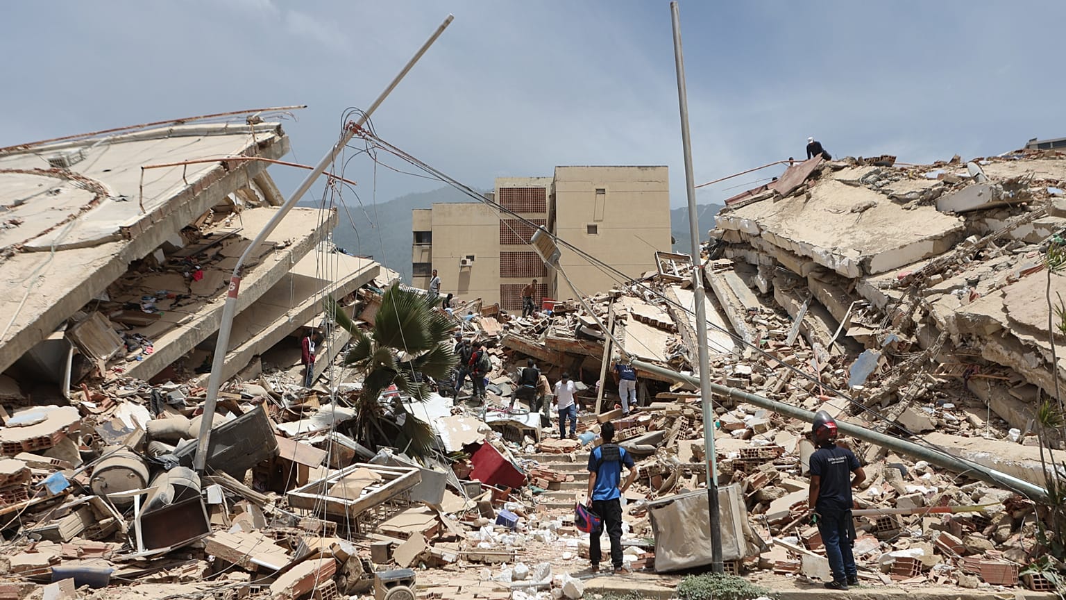 Residentes buscan entre los escombros de las casas dañadas durante el terremoto y varias réplicas que sacudieron La Guaira, Venezuela