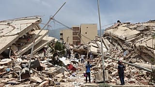 Residentes buscan entre los escombros de las casas dañadas durante el terremoto y varias réplicas que sacudieron La Guaira, Venezuela