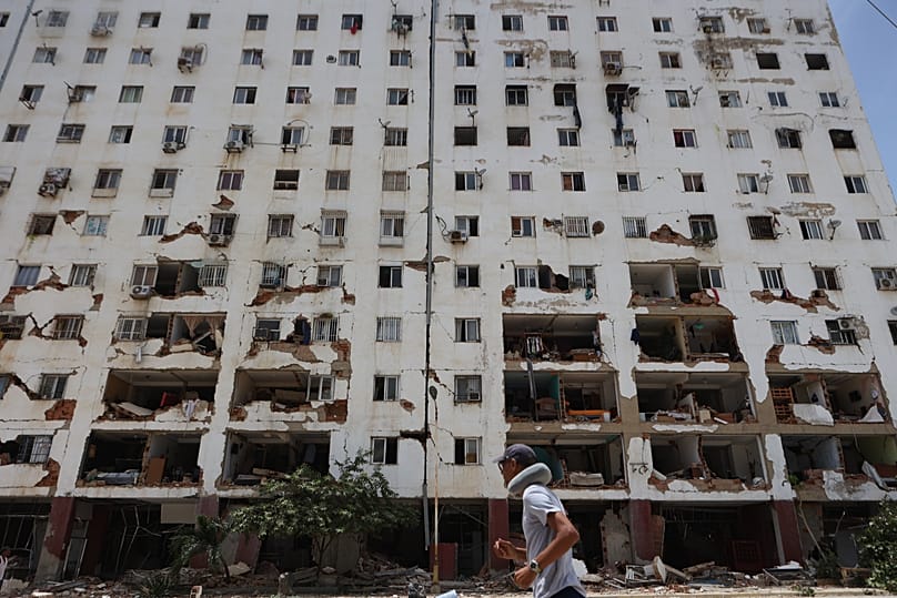 Un residente pasa junto a un edificio dañado tras el terremoto y varias réplicas que sacudieron La Guaira, Venezuela