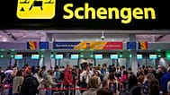 Passengers arriving at the Henri Coanda International Airport pass under a Schengen Information sign, in Otopeni, near Bucharest, Romania.