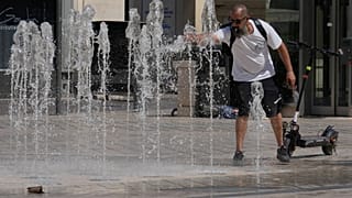Un homme se rafraîchit à une fontaine lors d'une vague de chaleur à Saint-Germain-en-Laye, à l'ouest de Paris, le jeudi 25 juin 2026.