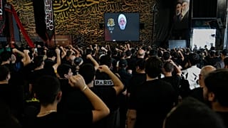 أنصار حزب الله يرفعون قبضاتهم وهم يستمعون إلى خطاب زعيم حزب الله الشيخ نعيم قاسم خلال خطبة بمناسبة اليوم الأول من عاشوراء