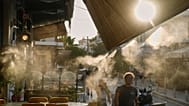 Pedestrians walk next to a mist machine in Thisio district of Athens during a heatwave, July 2025.