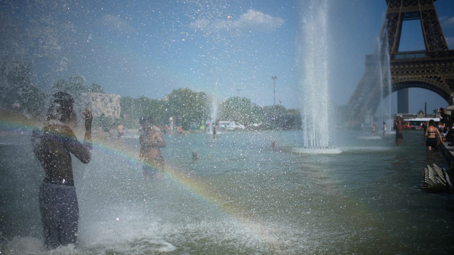 Des passants viennent se rafraîchir à la fontaine du Trocadéro, près de la tour Eiffel, lors d'une vague de chaleur à Paris, ce mercredi 24 juin 2026. 