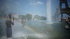 Des passants viennent se rafraîchir à la fontaine du Trocadéro, près de la tour Eiffel, lors d'une vague de chaleur à Paris, ce mercredi 24 juin 2026. 