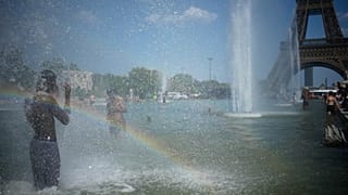 Des passants viennent se rafraîchir à la fontaine du Trocadéro, près de la tour Eiffel, lors d'une vague de chaleur à Paris, ce mercredi 24 juin 2026. 
