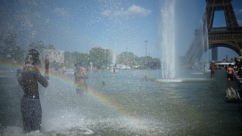 Des passants viennent se rafraîchir à la fontaine du Trocadéro, près de la tour Eiffel, lors d'une vague de chaleur à Paris, ce mercredi 24 juin 2026. 