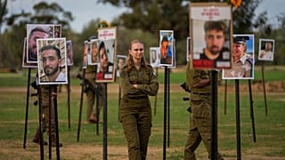 ينظر جنود إسرائيليون إلى صور لأشخاص قُتلوا واختُطفوا على يد مسلحي حركة حماس خلال هجومهم على مهرجان "نوفا" الموسيقي في جنوب إسرائيل؛ يوم الثلاثاء الموافق 28 نوفمبر 2023. 