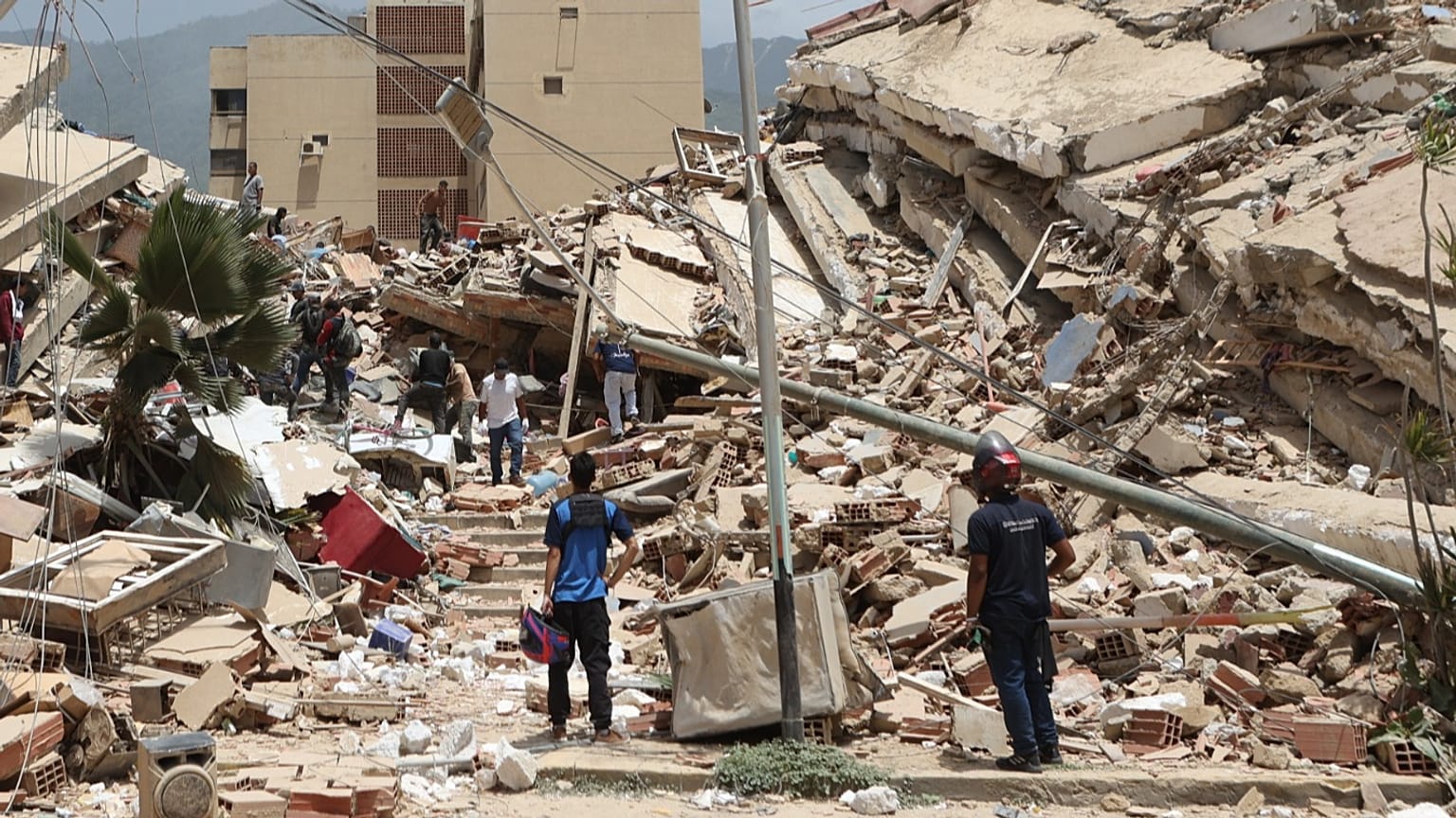 Los residentes buscan entre los escombros de las casas dañadas durante el terremoto y las réplicas que azotaron La Guaira, Venezuela, el 25 de junio de 2026.