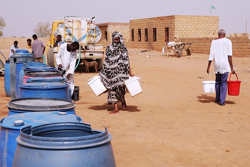 سودانيون يملأون عبوات المياه من نقطة توزيع مجانية، في ظل انقطاع إمدادات المياه في الخرطوم، السودان، في 18 مايو 2026.
