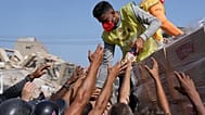  Miembros de una organización religiosa distribuyen alimentos a las personas afectadas dos días después del terremoto que azotó La Guaira, Venezuela, el 26 de junio de 2026.