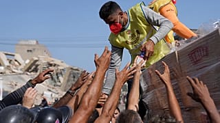  Miembros de una organización religiosa distribuyen alimentos a las personas afectadas dos días después del terremoto que azotó La Guaira, Venezuela, el 26 de junio de 2026.