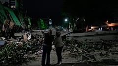 Жители наблюдают за разрушенными зданиями после землетрясения в Каракасе, Венесуэла, 25 июня 2026 года.