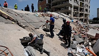 Residents and rescue workers search for survivors in Catia aa Mar, Venezuela, Friday, June 26, 2026, two days after twin earthquakes struck the country.