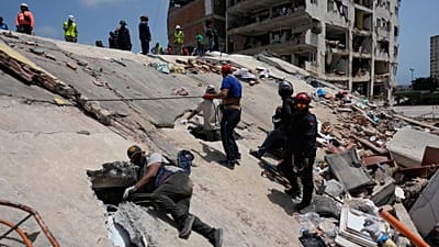 Residents and rescue workers search for survivors in Catia aa Mar, Venezuela, Friday, June 26, 2026, two days after twin earthquakes struck the country.