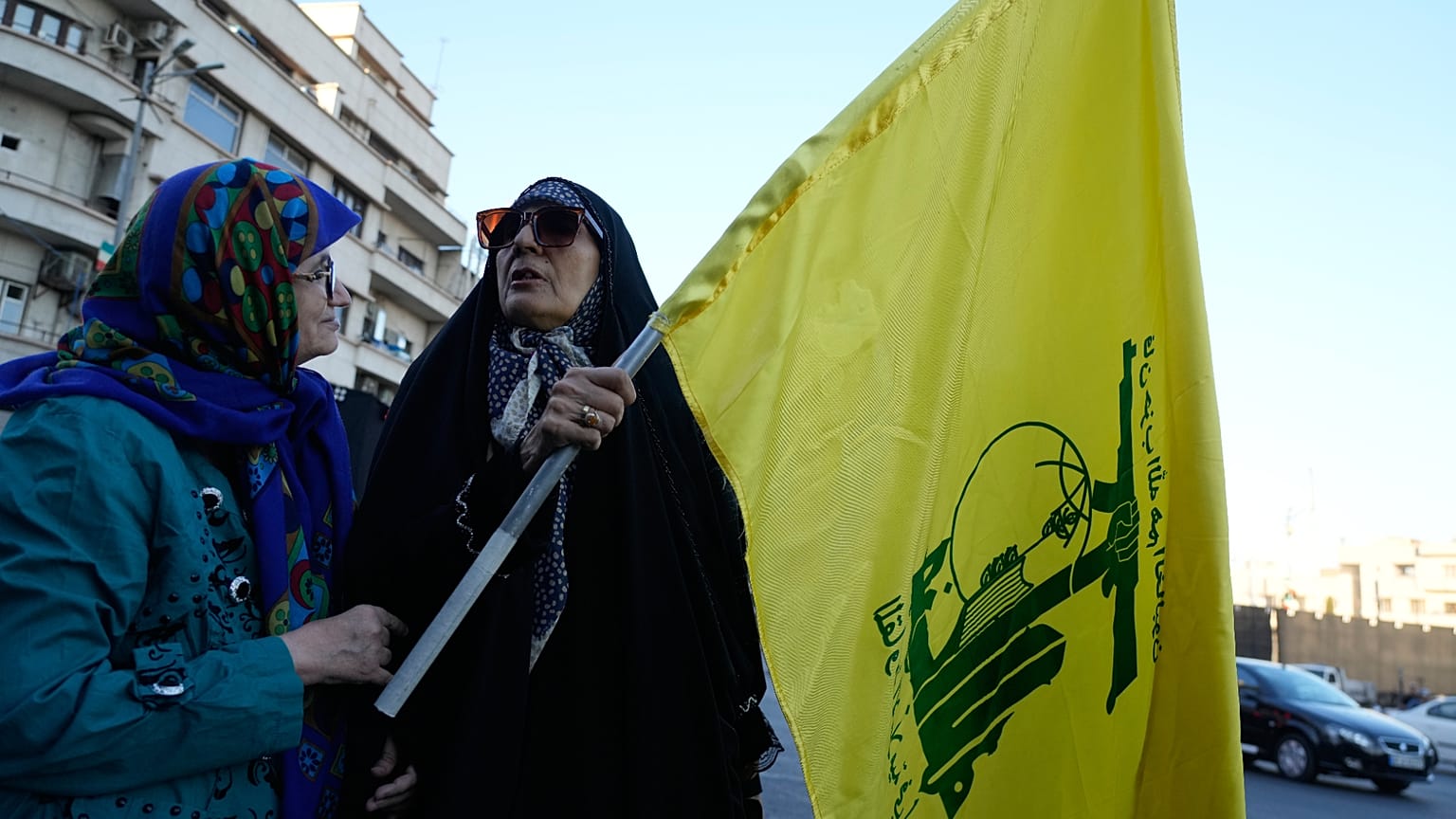 امرأة تحمل علم جماعة حزب الله اللبنانية المسلحة خلال تجمع لمجموعة صغيرة في ساحة الثورة الإسلامية في طهران، إيران، الأحد 14 يونيو 2026. (AP Photo/فاهد سليمي)