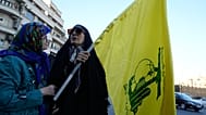 امرأة تحمل علم جماعة حزب الله اللبنانية المسلحة خلال تجمع لمجموعة صغيرة في ساحة الثورة الإسلامية في طهران، إيران، الأحد 14 يونيو 2026. (AP Photo/فاهد سليمي)