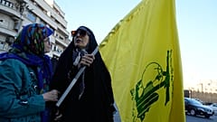 امرأة تحمل علم جماعة حزب الله اللبنانية المسلحة خلال تجمع لمجموعة صغيرة في ساحة الثورة الإسلامية في طهران، إيران، الأحد 14 يونيو 2026. (AP Photo/فاهد سليمي)