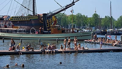 People cool off near the replica of a 18th-century VOC (Dutch East India Company) vessel during a heatwave in Amsterdam, Netherlands, Thursday, June 25, 2026.