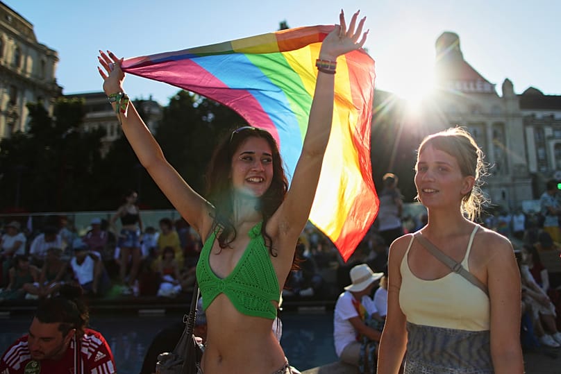 Egy lány szivárványzászlót tart a kezében a budapesti Pride-felvonuláson, Magyarországon, 2025. június 28-án