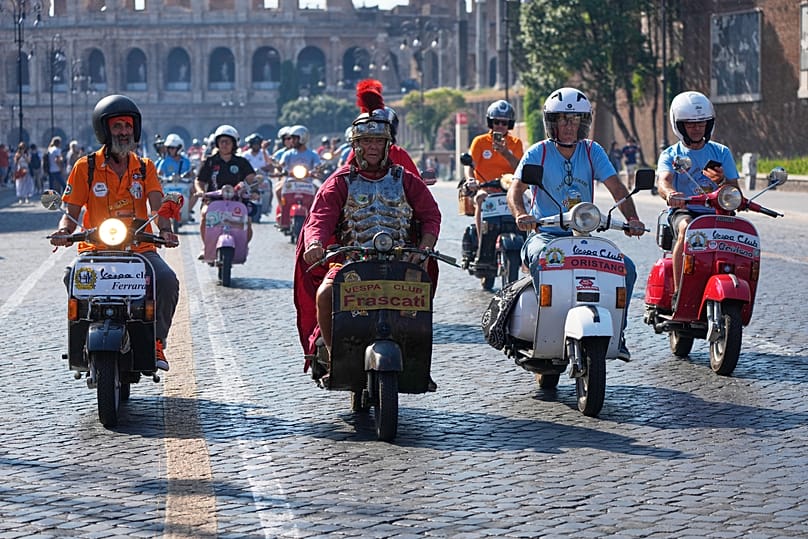 Любители Vespa участвуют в параде во время празднования 80-летия скутера Vespa в Риме, в субботу, 27 июня 2026 года. (AP Photo/Alessandra Tarantino)