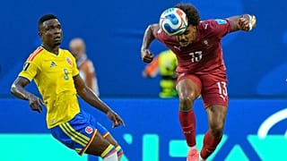 Renato Veiga afasta uma bola de cabeça, sob o olhar de Córdoba