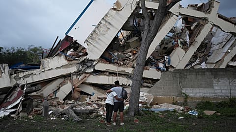 A couple embraces in front of a building destroyed by twin earthquakes three days after they struck La Guaira, Venezuela, Saturday, June 27, 2026.