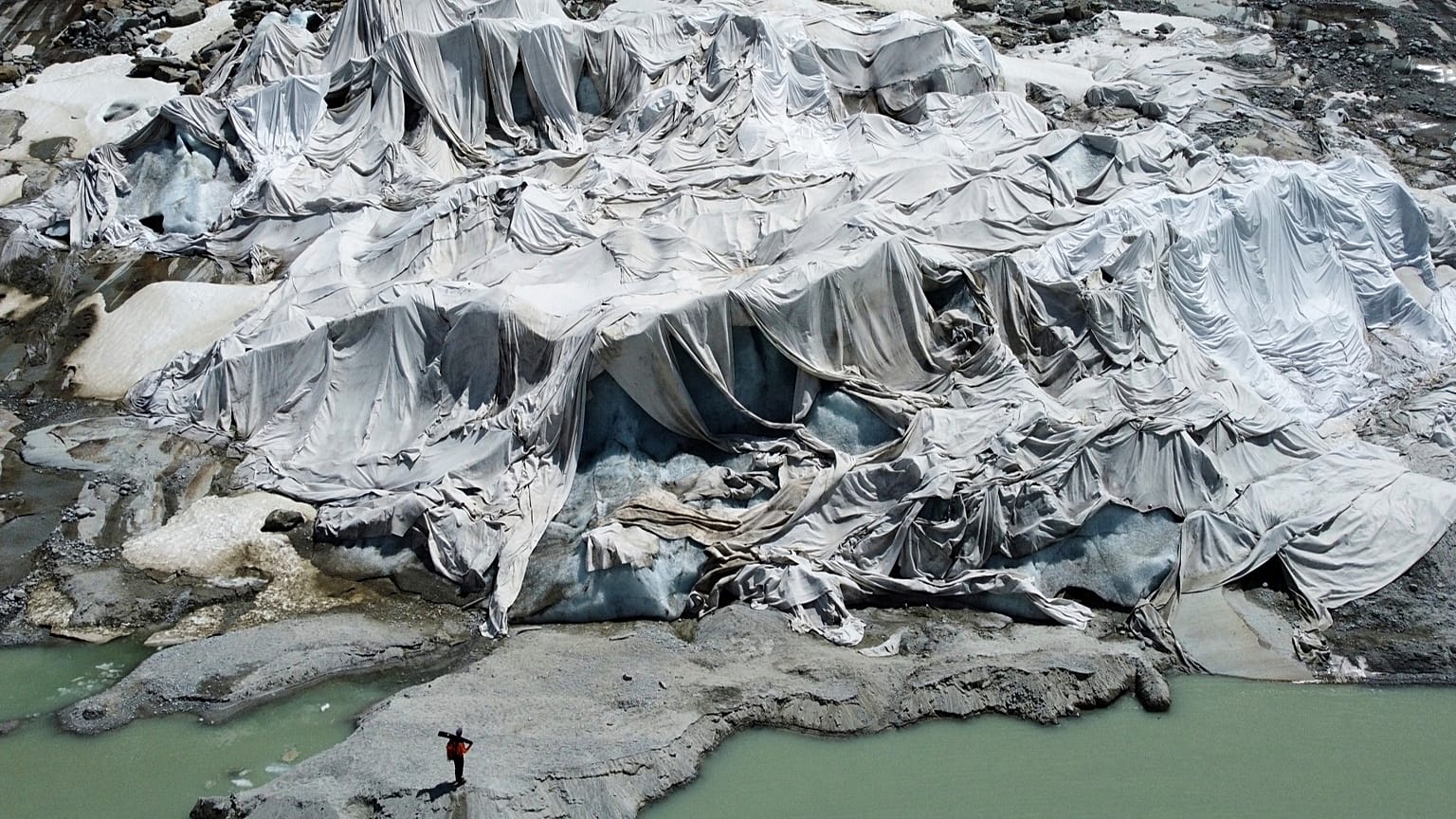 ARCHIVO - Matthias Huss, del grupo glaciológico GLAMOS, junto al glaciar del Ródano cubierto con lonas cerca de Goms, Suiza, el diez de junio de 2025.