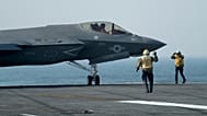 FILE: Marinheiros dos EUA caminham junto de um caça F-35 no convés do porta-aviões USS George Washington durante exercícios ao largo da Argentina, 30 maio 2024