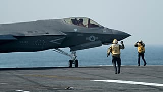 FILE: US Navy sailors walk beside a F-35 fighter jet on the deck of aircraft carrier USS George Washington during joint exercises off the coast of Argentina, 30 May 2024