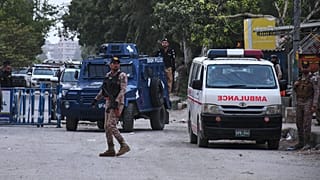 Soldados y agentes montan guardia en una carretera cerca del lugar de un ataque militante en la sede provincial de los Rangers de Pakistán, en Karachi, el 28 de junio de 2026.