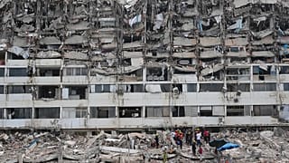 Rescue workers search through the rubble of a building that collapsed when earthquakes struck La Guaira, 28 June, 2026