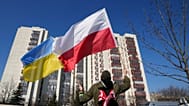 [Archiwum] Mężczyzna macha flagami Ukrainy i Polski podczas demonstracji przed budynkiem, w którym mieszczą się rosyjscy dyplomaci w Warszawie, w niedzielę 13 marca 2022 r. 
