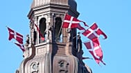 Danish flags are attached to the spire of Christiansborg Castle, the Danish Parliament building in Copenhagen, Denmark, Sept. 5, 2021.