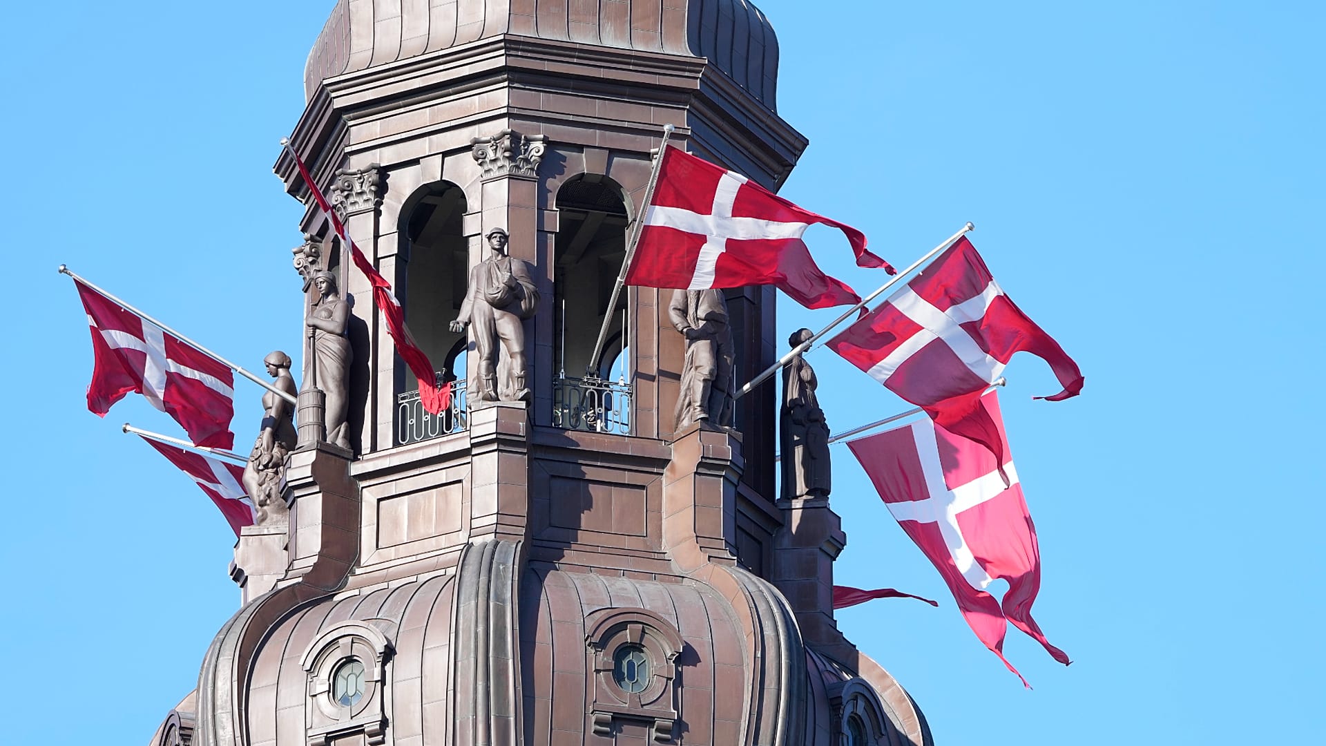 Des drapeaux danois sont hissés sur la flèche du château de Christiansborg, siège du Parlement à Copenhague, le 5 septembre 2021.