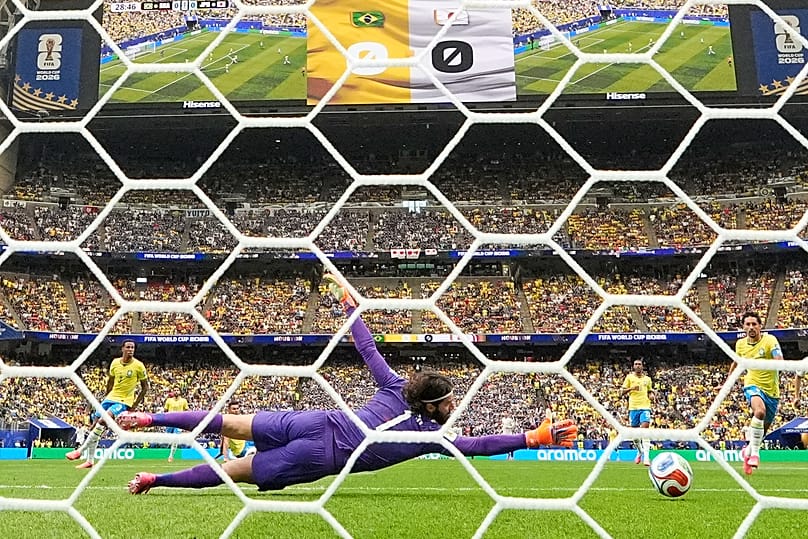 Japan's Kaishu Sano (24) scores their opening goal past Brazil goalkeeper Alisson Becker 
