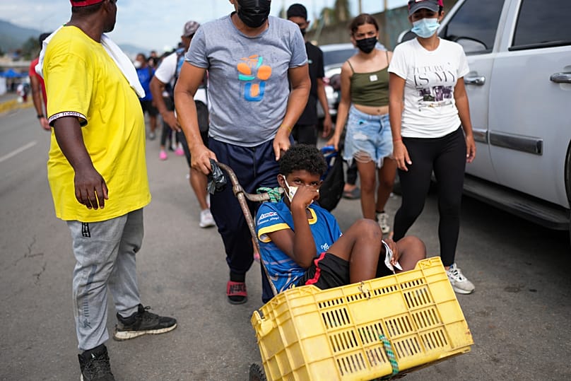 Ein Junge wird in einer Schubkarre transportiert