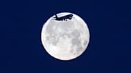 A TAP Air Portugal aircraft approaches landing in Lisbon at sunrise with the full moon behind it, Monday, June 1, 2026.