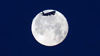 Un avion de TAP Air Portugal atterrit à Lisbonne au lever du soleil, avec la pleine lune en arrière-plan, lundi 1er juin 2026.