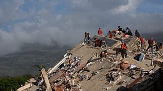 Rescue workers search through the rubble of a building that collapsed when earthquakes struck Catia La Mar, 29 June, 2026