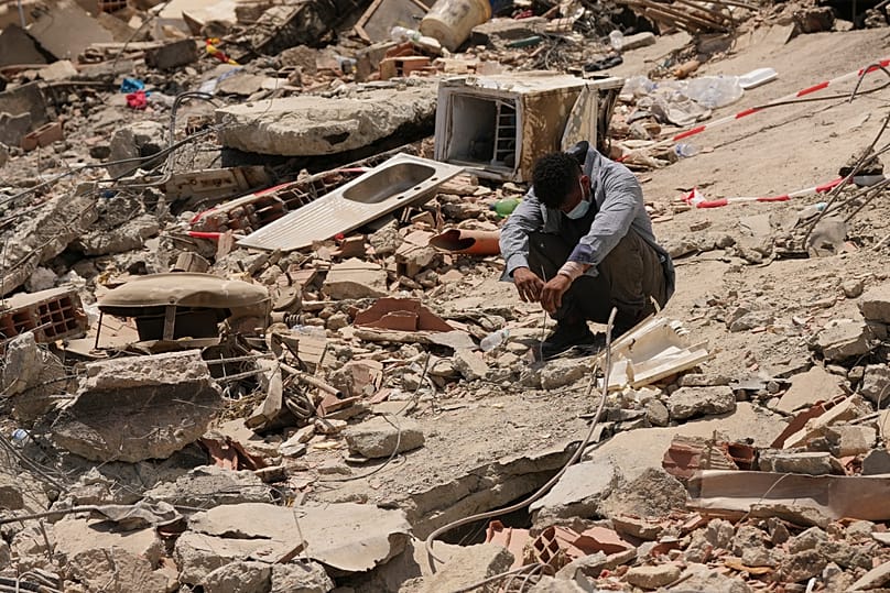 A man sits amid earthquake rubble in La Guaira, 29 June, 2026