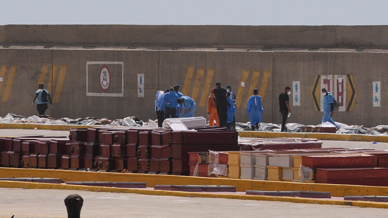 Adli tıp görevlileri, Venezuela'nın La Guaira limanında deprem kurbanlarının bedenlerini tabutlara yerleştiriyor, Pazartesi, 29 Haziran 2026