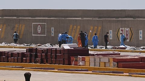 Adli tıp görevlileri, Venezuela'nın La Guaira limanında deprem kurbanlarının bedenlerini tabutlara yerleştiriyor, Pazartesi, 29 Haziran 2026