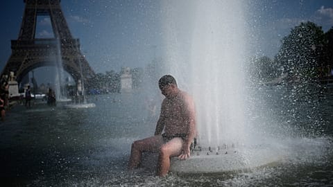 People cool off at Trocadero fountain near the Eiffel Tower during a heat wave in Paris, Wednesday, June 24, 2026. (AP Photo/Christophe Ena)