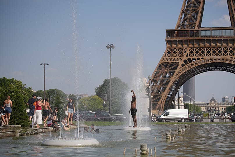 People cool off at Trocadero fountain near the Eiffel Tower during a heat wave in Paris, Wednesday, June 24, 2026.