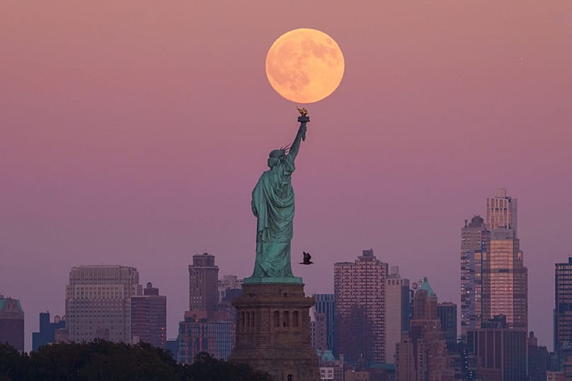 ARŞİV - Hasat süper dolunayı, 6 Ekim 2025'te New Jersey eyaletindeki Jersey City'de, Özgürlük Heykeli'nin ve Brooklyn silüetinin ardında yükseliyor.