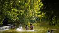 Youngsters play in a lake on a torrid day, as the National Weather forecaster issued an extreme heat code red warning for most parts of the country, in Bucharest, Romania. 