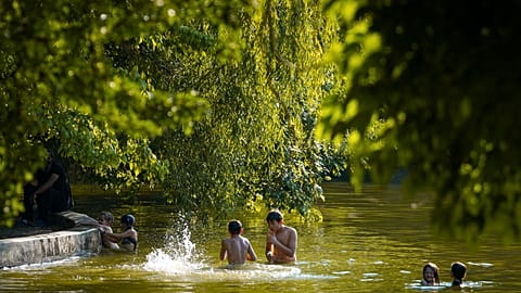Youngsters play in a lake on a torrid day, as the National Weather forecaster issued an extreme heat code red warning for most parts of the country, in Bucharest, Romania. 