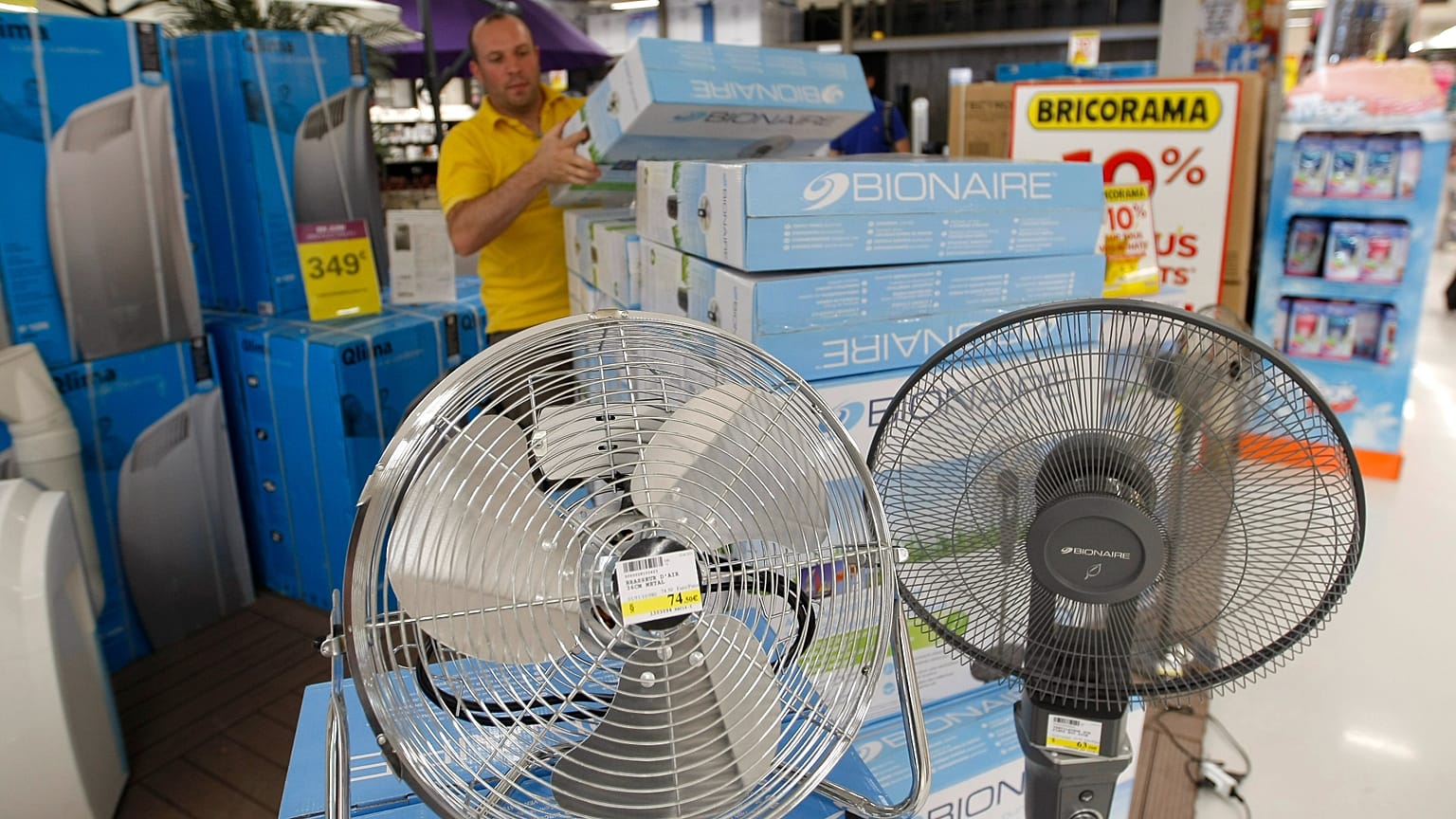 Archivbild: Ein Ladenmitarbeiter räumt in Marseille im Süden Frankreichs ein Regal mit Sommer-Klimaprodukten ein, am dritten Juli 2015.